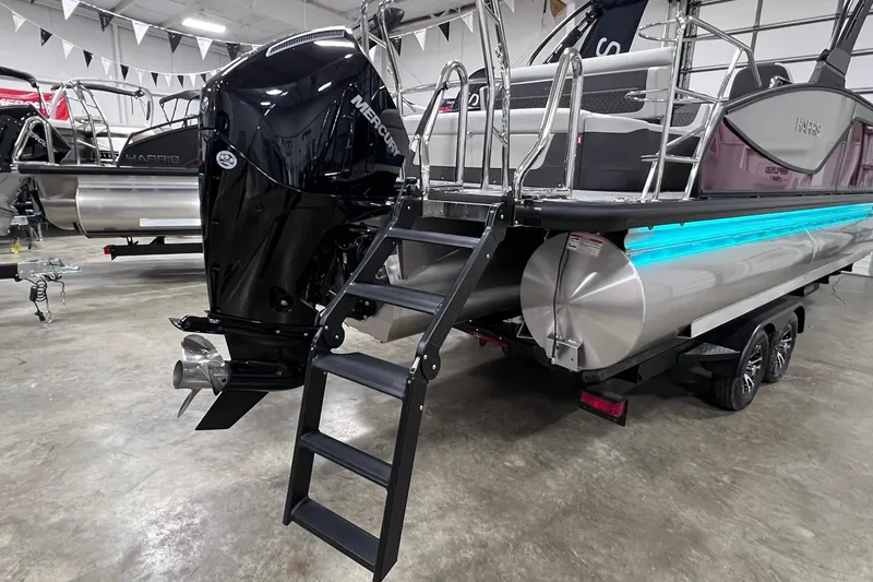 Slide: The Image of 2026 Harris Sunliner 250 SLE pontoon boat with Mercury engine and trailer in showroom. - 31