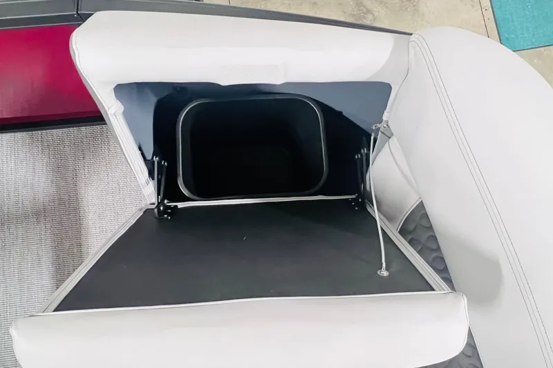 Slide: The Image of Open storage compartment in 2026 Harris Sunliner 250 SLE boat with white upholstery. - 42