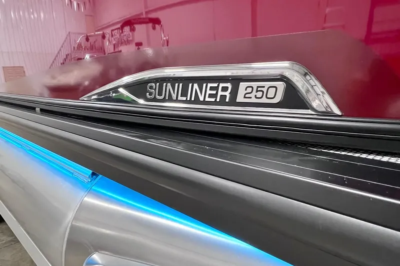 Slide: The Image of 2026 Harris Sunliner 250 SLE boat with sleek design and illuminated blue accents. - 55