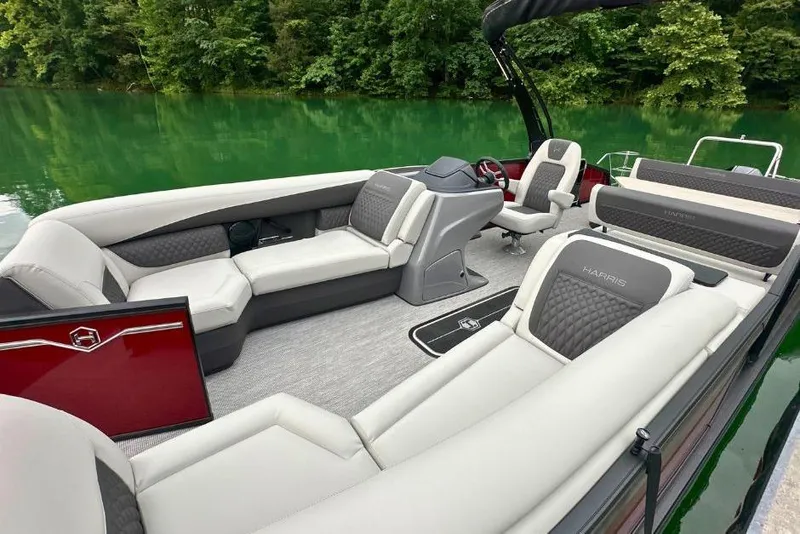 Slide: The Image of 2026 Harris Sunliner 250 SLE pontoon boat interior with luxurious seating on a serene lake. - 9