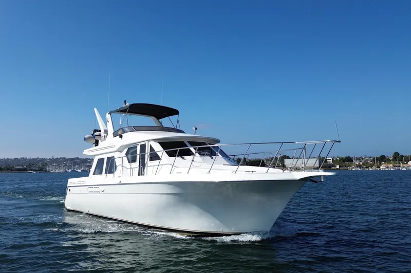 Slide: The Image of 1998 Navigator 4800 yacht cruising on a clear blue sea under a sunny sky. - 1