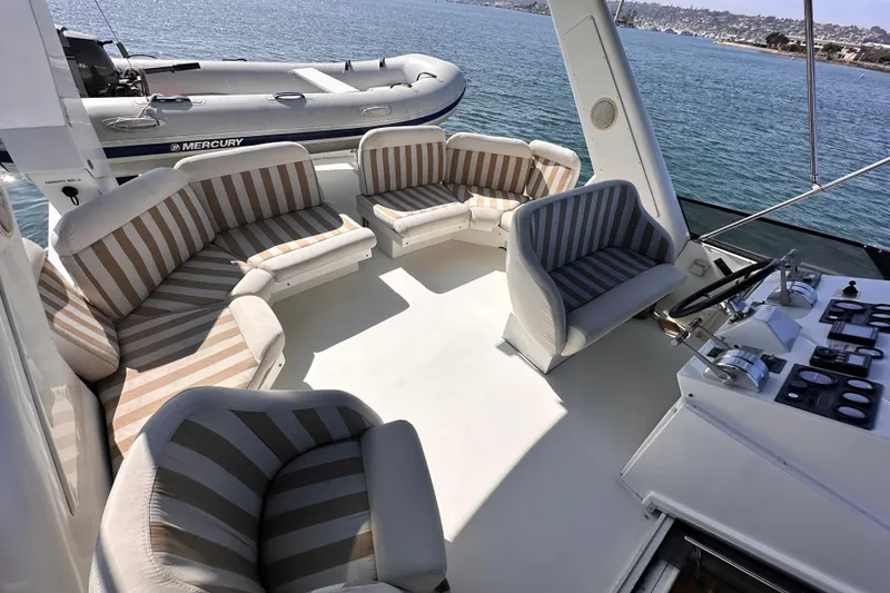 Slide: The Image of 1998 Navigator 4800 yacht interior with striped seating and control panel, overlooking the ocean. - 11