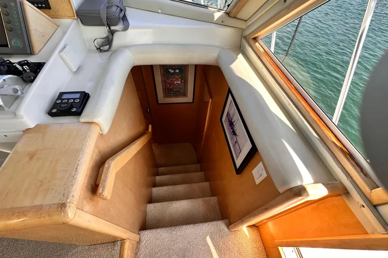 Slide: The Image of Staircase inside 1998 Navigator 4800 yacht, with wood paneling and framed artwork. - 20
