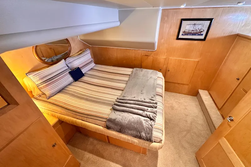 Slide: The Image of Cozy bedroom in 1998 Navigator 4800 yacht with striped bedding and wooden paneling. - 23