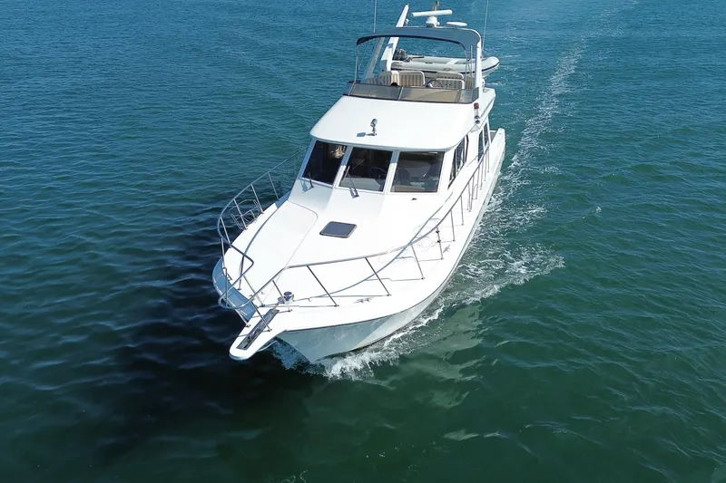 Slide: The Image of 1998 Navigator 4800 yacht cruising on open water, aerial view. - 4