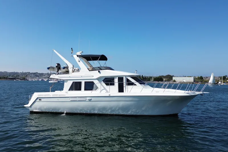 Slide: The Image of 1998 Navigator 4800 yacht on calm water under clear blue sky. - 7