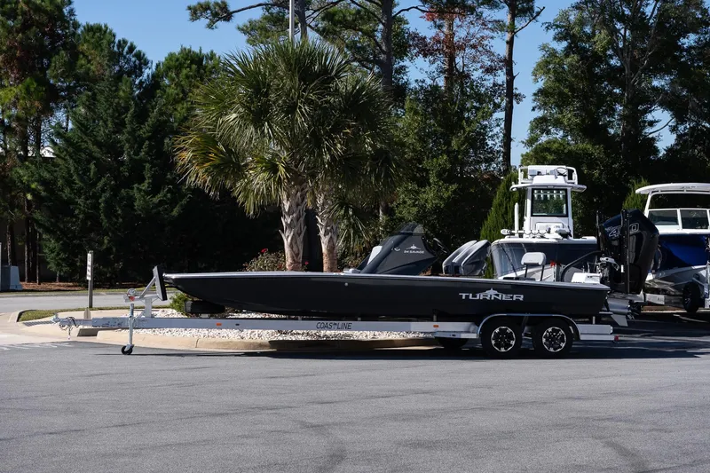 The Image of 2026 Turner Boatworks 24 SAVAGE on trailer, parked outdoors with trees in background. - 13