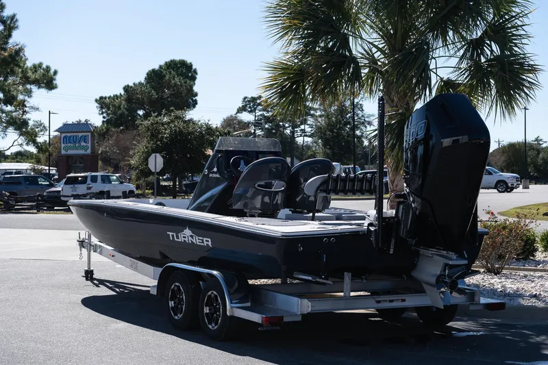 Slide: The Image of 2026 Turner Boatworks 24 SAVAGE on trailer, parked outdoors near palm tree. - 17