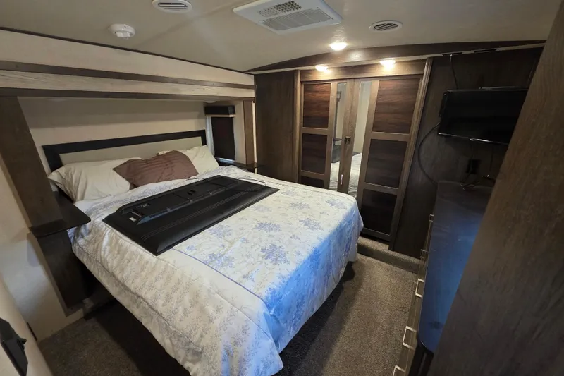 Slide: The Image of 2018 Heritage Glen 356QB bedroom interior with bed, TV, and wooden closet. - 14