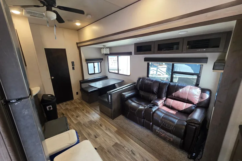 Slide: The Image of 2018 Heritage Glen 356QB interior with leather sofa, dining area, and wood flooring. - 18