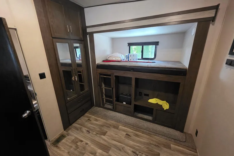 Slide: The Image of 2018 Heritage Glen 356QB interior with bunk bed, storage cabinets, and wood flooring. - 22
