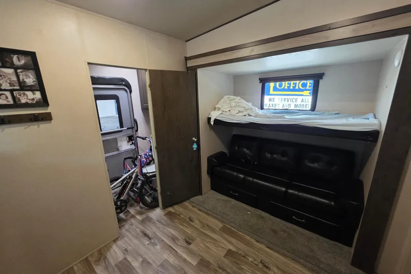 Slide: The Image of 2018 Heritage Glen 356QB interior with bunk bed, sofa, and bicycle storage. - 24