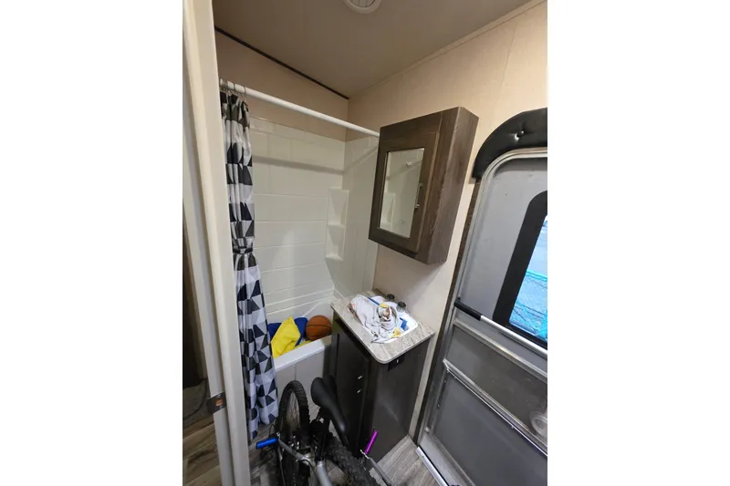 Slide: The Image of 2018 Heritage Glen 356QB bathroom with shower, cabinet, and bicycle storage. - 25