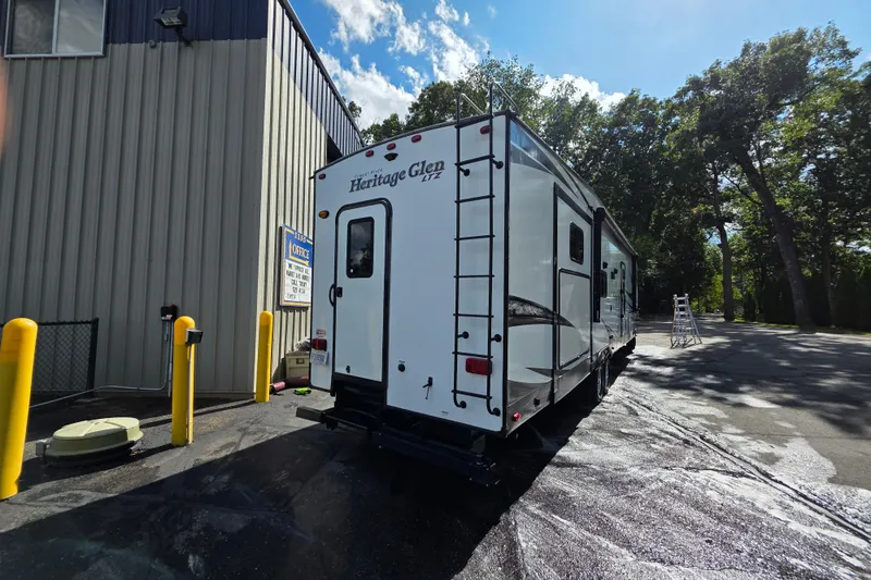Slide: The Image of 2018 Heritage Glen 356QB RV parked outside a building under a clear sky. - 5