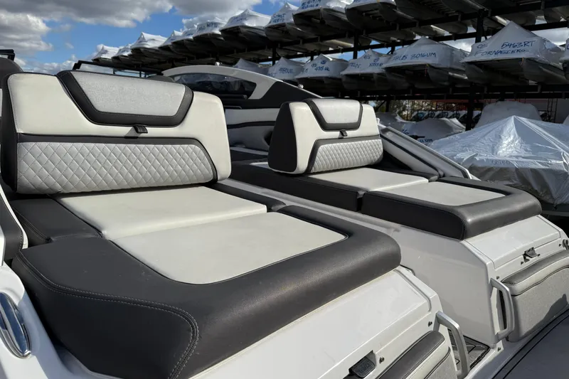 Slide: The Image of 2021 Yamaha Boats 275 E with luxurious seating and sleek design under a clear sky. - 13