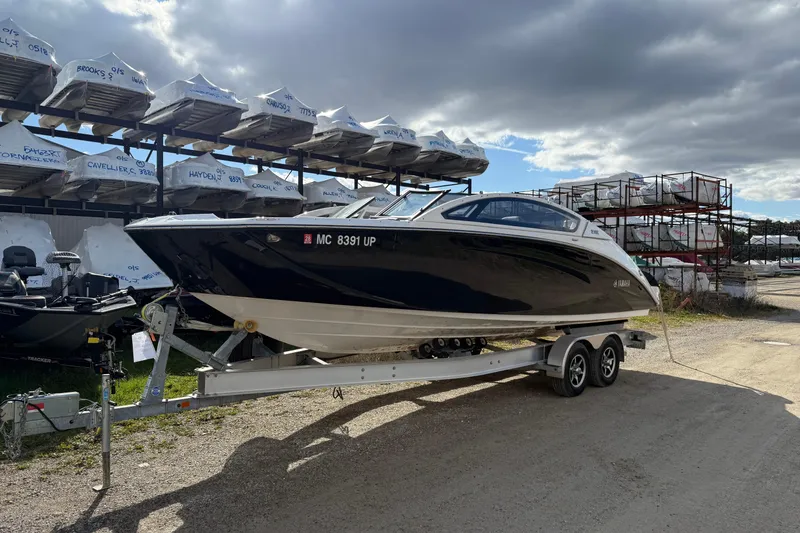 Slide: The Image of 2021 Yamaha Boats 275 E on trailer in storage yard under cloudy sky. - 3