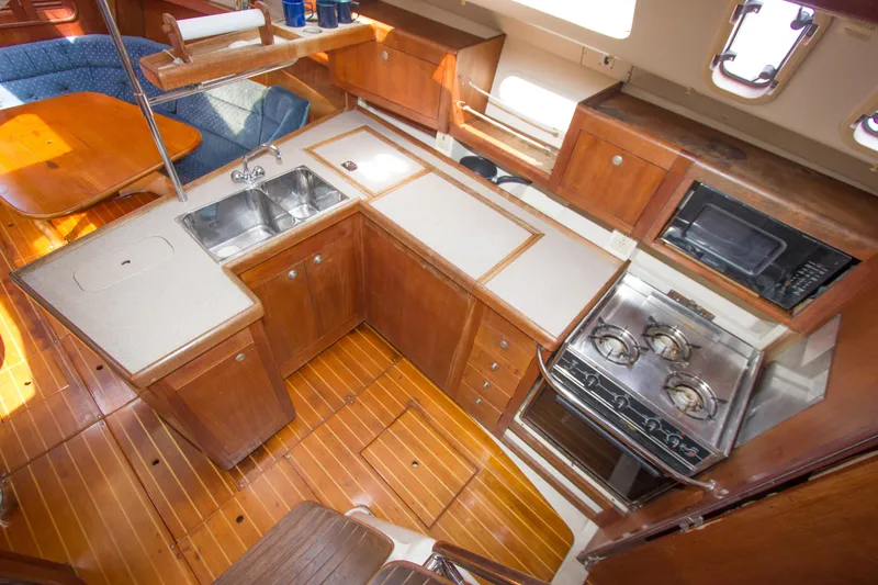 Slide: The Image of Interior of 1997 Hunter 376 sailboat galley with wood cabinetry and modern appliances. - 10