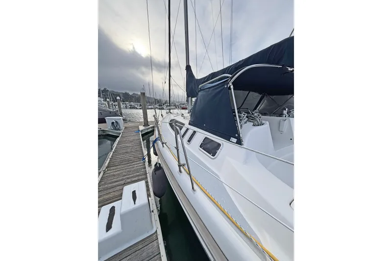 Slide: The Image of 1997 Hunter 376 sailboat docked at marina under cloudy sky. - 20