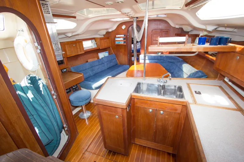 Slide: The Image of Interior of a 1997 Hunter 376 sailboat with wooden cabinetry and cozy seating area. - 3