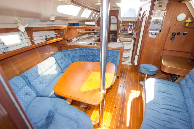 Slide: The Image of Interior of a 1997 Hunter 376 sailboat with blue seating and wooden finishes. - 6