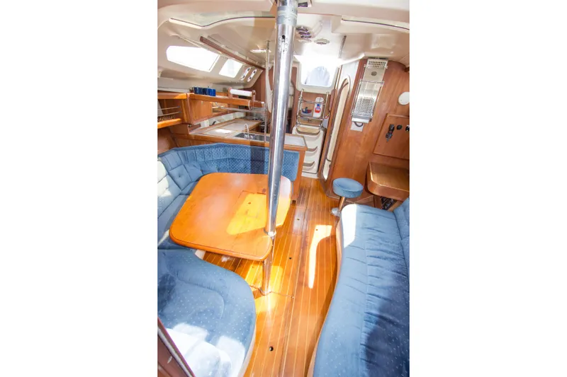 Slide: The Image of Interior of 1997 Hunter 376 sailboat with wooden flooring and blue seating. - 7