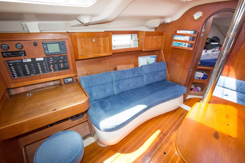 Slide: The Image of Interior of a 1997 Hunter 376 sailboat with wood paneling and blue seating. - 8