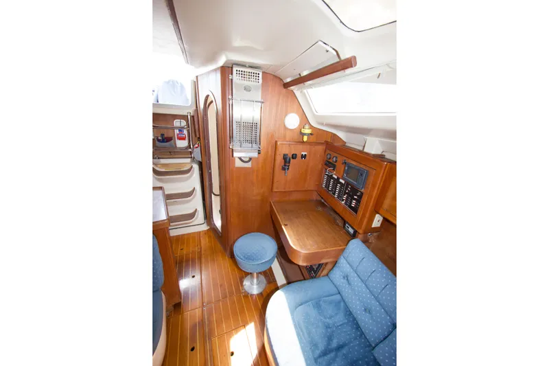 Slide: The Image of Interior of a 1997 Hunter 376 sailboat featuring wood paneling and navigation station. - 9