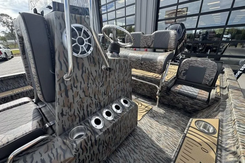 Slide: The Image of 2026 Xpress H22B Bay boat interior with camo design, featuring seating and speaker system. - 17