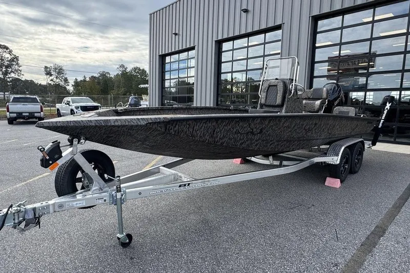 Slide: The Image of 2026 Xpress H22B Bay boat on trailer outside a showroom. - 5