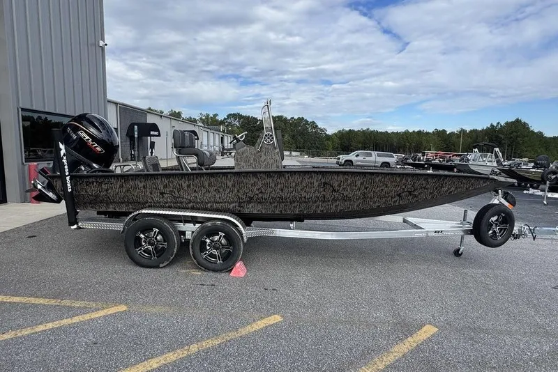 Slide: The Image of 2026 Xpress H22B Bay boat on trailer, parked outdoors near a building. - 6