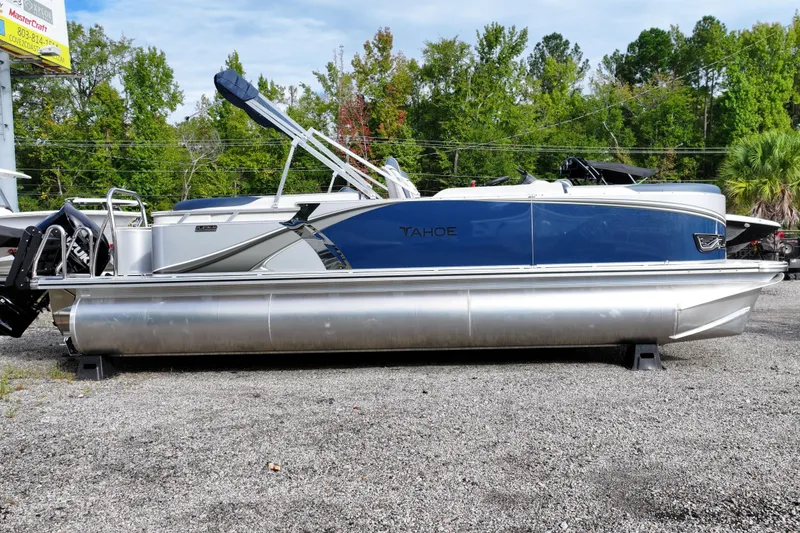 Slide: The Image of 2026 Tahoe Pontoon LTZ Quad Lounger, blue and silver, parked outdoors on gravel. - 7