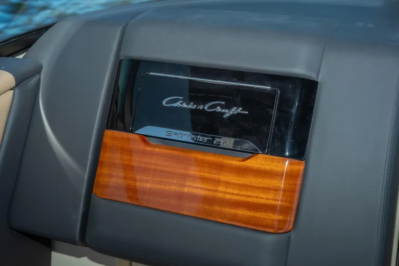 Slide: The Image of Dashboard of 2026 Chris-Craft Sportster 28 with wood and leather accents. - 14