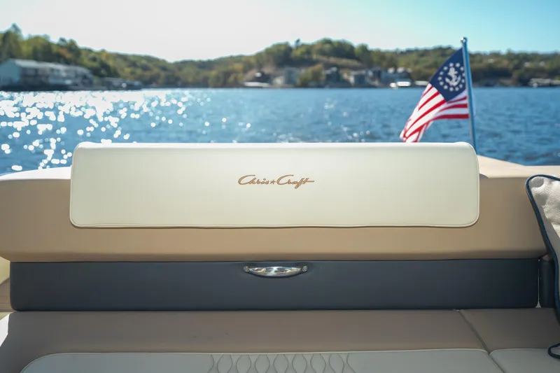 Slide: The Image of 2026 Chris-Craft Sportster 28 boat interior with American flag on a sunny lake. - 16