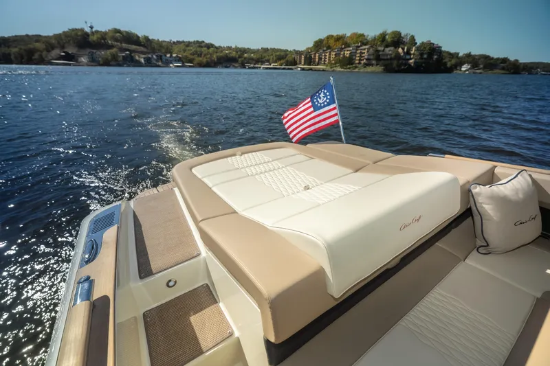 Slide: The Image of 2026 Chris-Craft Sportster 28 on a lake, featuring luxurious seating and American flag. - 17