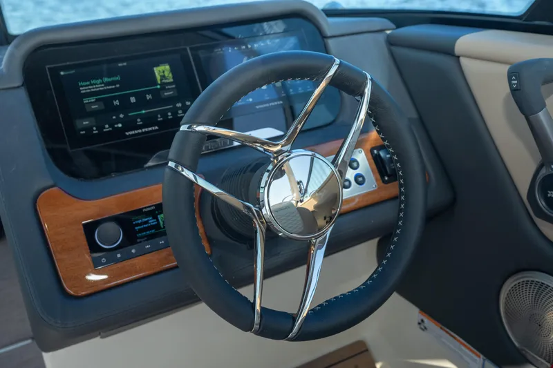 Slide: The Image of Steering wheel and dashboard of 2026 Chris-Craft Sportster 28 boat, featuring modern controls. - 23
