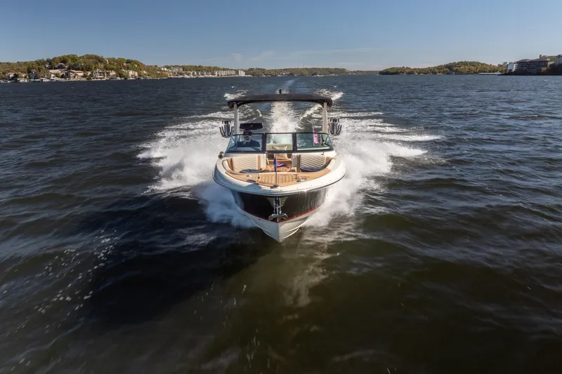 Slide: The Image of 2026 Chris-Craft Sportster 28 cruising on a scenic lake under clear skies. - 35