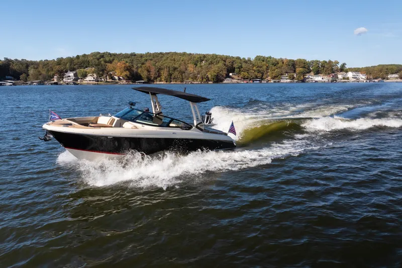 Slide: The Image of 2026 Chris-Craft Sportster 28 cruising on a scenic lake under clear skies. - 4