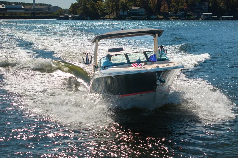 Slide: The Image of 2026 Chris-Craft Sportster 28 cruising on a sunny lake, creating a dynamic water wake. - 6