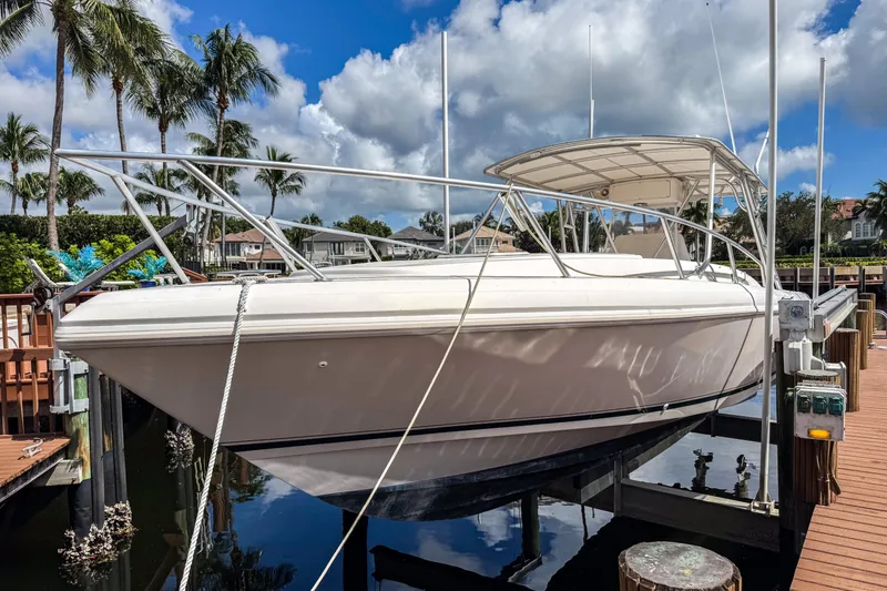 The Image of 1999 Intrepid 356 boat docked, surrounded by palm trees and blue sky. - 0