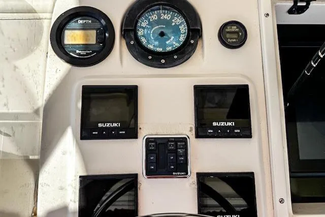 Slide: The Image of Control panel of a 1998 Intrepid 356 Cuddy boat with Suzuki displays and Garmin screen. - 12