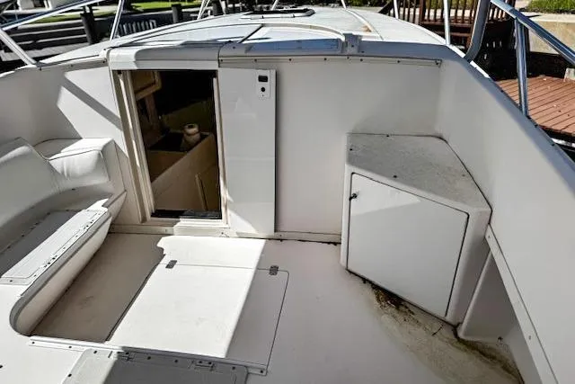 Slide: The Image of 1998 Intrepid 356 Cuddy boat storage compartment with latch, white interior. - 16
