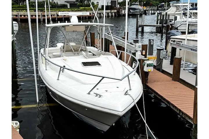 Slide: The Image of 1999 Intrepid 356 boat docked near luxury waterfront homes, surrounded by palm trees. - 2