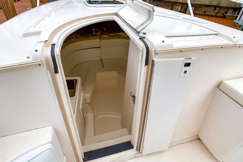 Slide: The Image of 1998 Intrepid 356 Cuddy cabin entrance, featuring sleek white interior and compact design. - 25