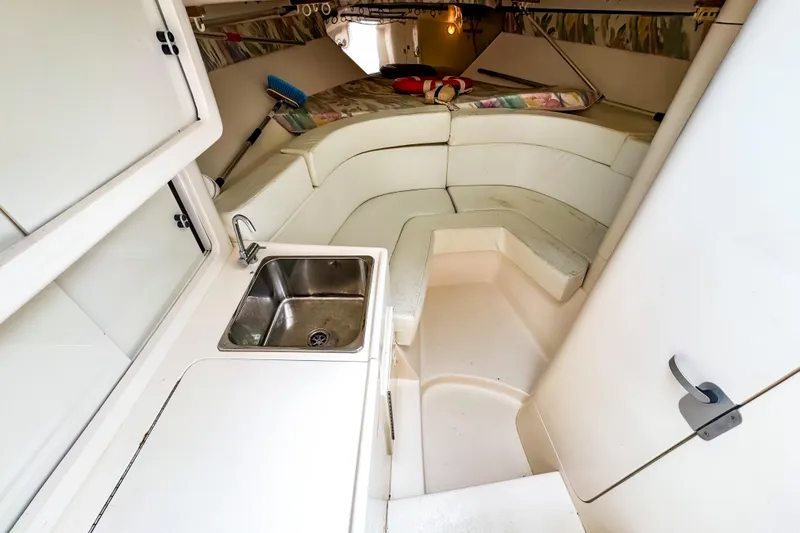Slide: The Image of 1998 Intrepid 356 Cuddy cabin interior with sink and seating area. - 26