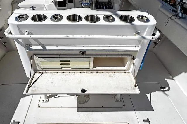 Slide: The Image of 1998 Intrepid 356 Cuddy boat interior with helm, rod holders, and docked setting. - 8