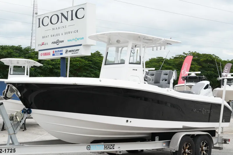 Slide: The Image of 2025 NauticStar 242 Offshore boat on trailer at Iconic Marine dealership. - 2