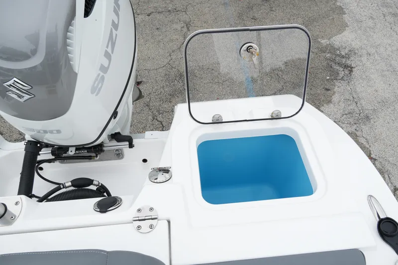 Slide: The Image of 2025 NauticStar 242 Offshore boat with Suzuki engine and open storage compartment. - 24