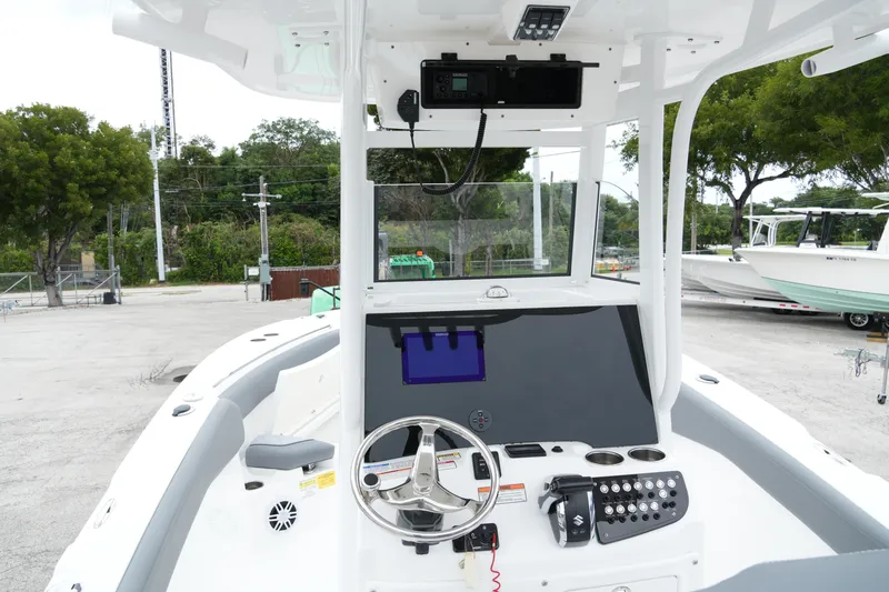 Slide: The Image of 2025 NauticStar 242 Offshore boat dashboard with steering wheel and navigation system. - 25