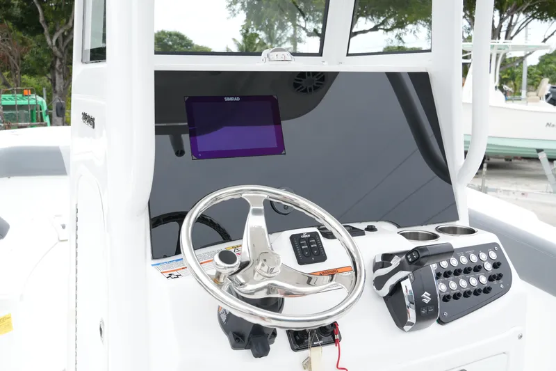 Slide: The Image of 2025 NauticStar 242 Offshore boat dashboard with steering wheel and control panel. - 28