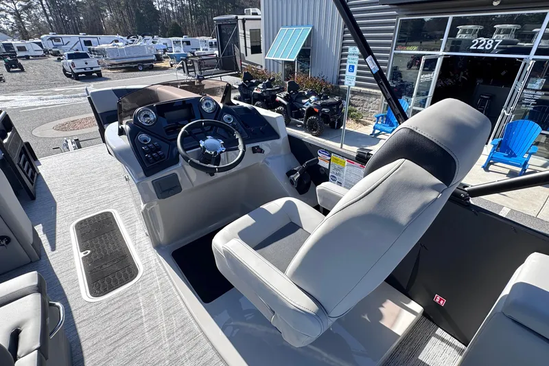 Slide: The Image of 2026 Sylvan L3 CLZ boat cockpit with modern steering and controls, parked outdoors. - 17